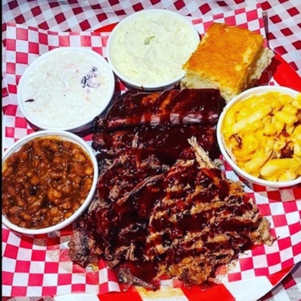 Real Smoq’ed BBQ platter with ribs, pulled pork, mac and cheese, baked beans, coleslaw, and cornbread.